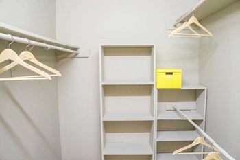 Closet with white shelves and hangers.